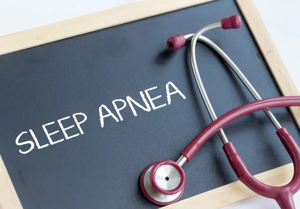 Sleep apnea written on a chalkboard with a stethoscope beside it